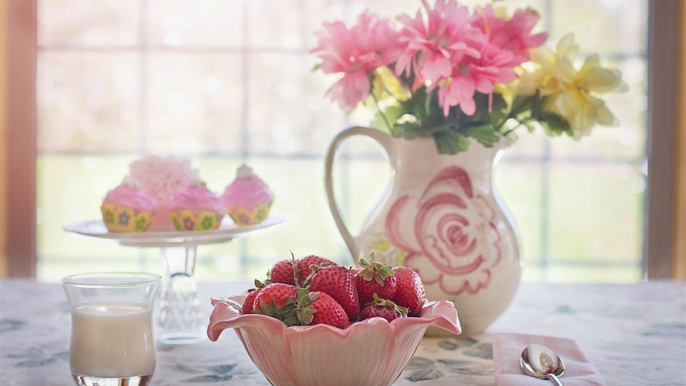 Desayuno saludable con fresas y leche junto a una ventana
