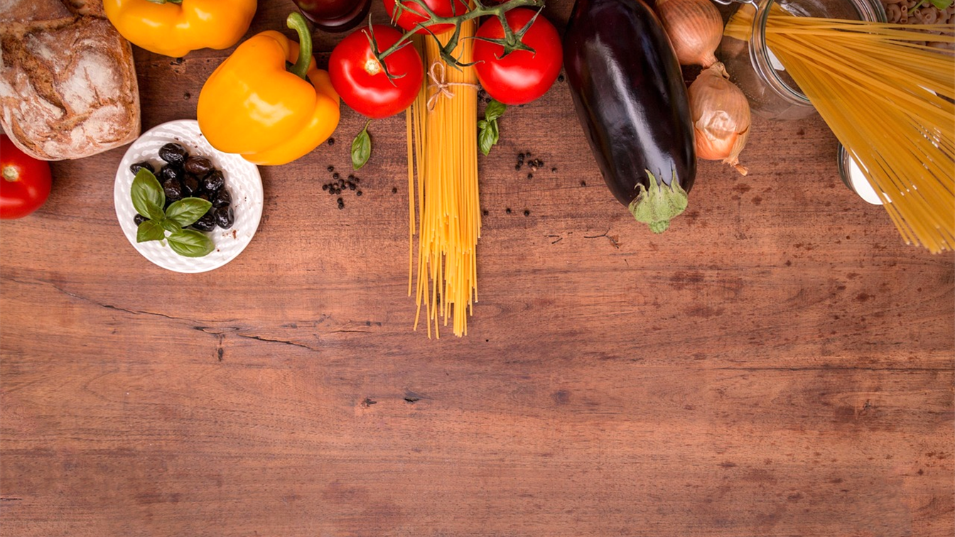 Verduras frescas y alimentos mediterráneos sobre una mesa de madera